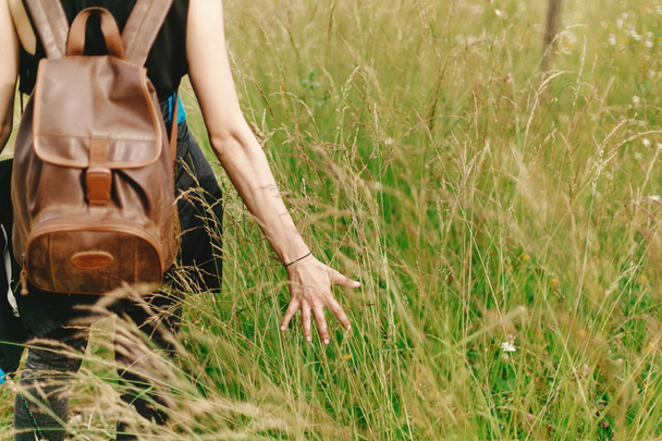  hipster traveler walking in grass - Фото, изображение