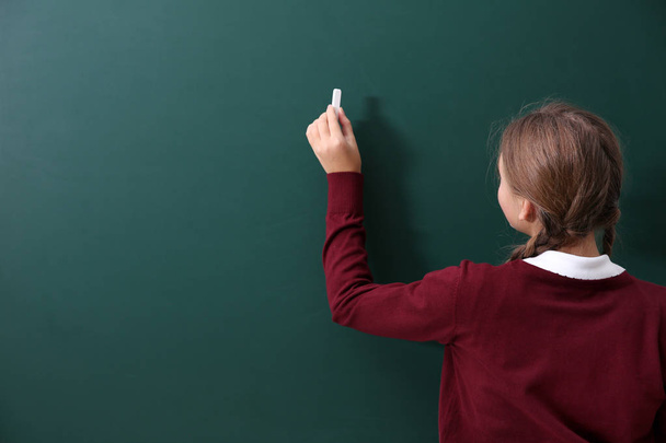 girl near green school blackboard - Valokuva, kuva