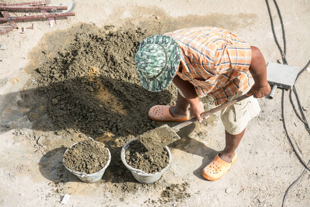 man mixing a cement in salver for applying construction  - Φωτογραφία, εικόνα