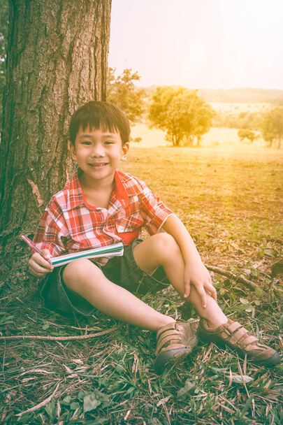 Happy asian boy smiling and holding a book. Education concept. Vintage tone. - Photo, Image