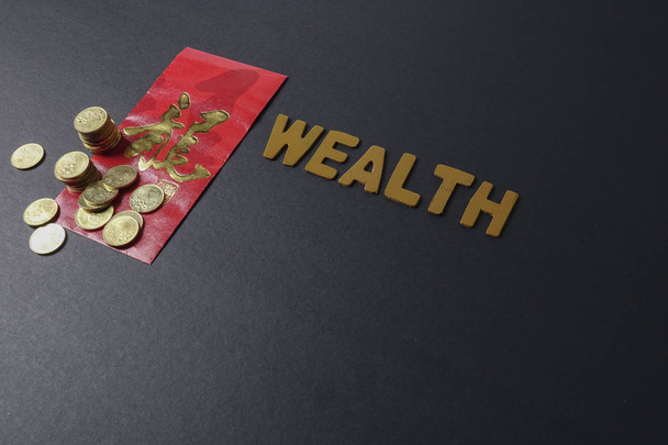 Κινέζικα κόκκινα πακέτο με τα κινεζικά φράση σημαίνει «καλή τύχη και ευημερία», χρυσά νομίσματα και διατύπωση του πλούτου. Φεστιβάλ κινεζικό νέο έτος. Συνθήκες χαμηλού φωτισμού. - Φωτογραφία, εικόνα