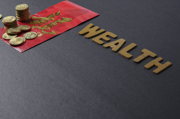 Paquet rouge chinois avec la phrase chinoise signifie "Bonne chance et prospérité", pièces d'or et libellé de WEALTH. Festival du Nouvel An chinois. Faible lumière
. - Photo, image