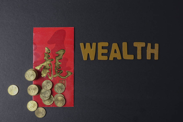 Paquete rojo chino con la frase china significa "Buena suerte y prosperidad", monedas de oro y la redacción de la riqueza. Festival de Año Nuevo Chino. Baja luz
. - Foto, imagen