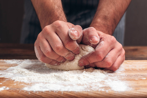 Male hands kneading dough close-up - Foto, Bild