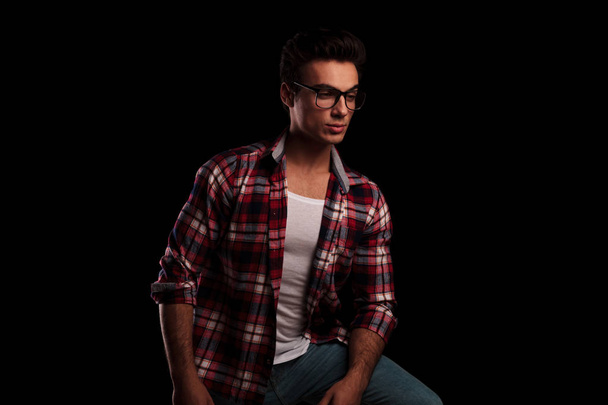 jeune homme sexy en chemise à carreaux et lunettes détournant les yeux
 - Photo, image