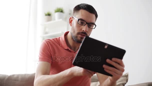 man with tablet pc tired from eyeglasses at home - Video