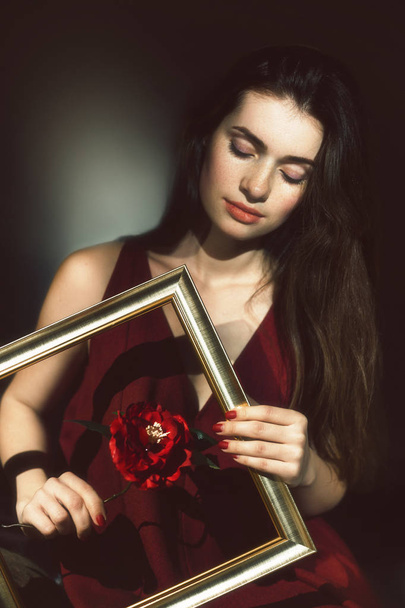 una joven morena sosteniendo una flor
 - Foto, imagen