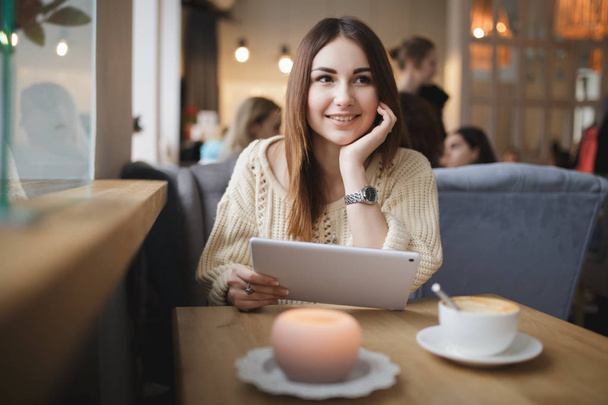 Cute woman using tablet pc in a cafe - Photo, image
