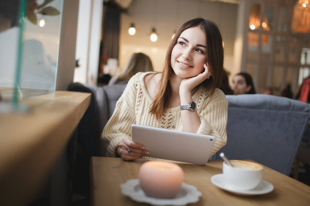 Cute woman using tablet pc in a cafe - Photo, Image