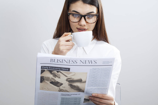 Geschäftsfrau liest Zeitung auf grauem Hintergrund - Foto, Bild