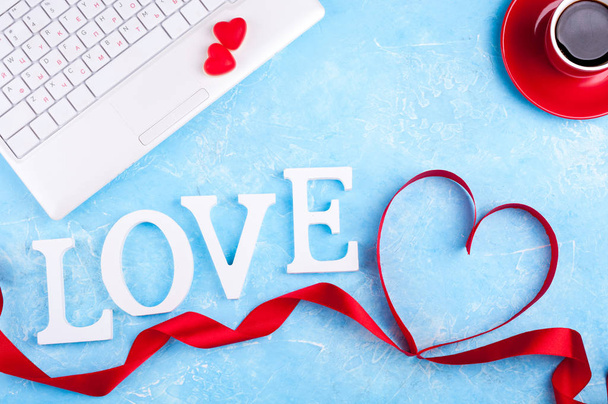 Valentinshintergrund mit rotem Herz, Kaffeetasse und Laptop. Valentinstag-Grußkarte. Frauenarbeitsplätze - Foto, Bild