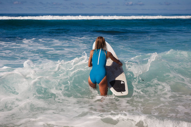 Female surfer with board in hands - Foto, afbeelding