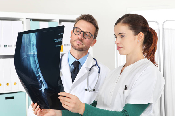 doctors looking at x-ray in medical office - Foto, afbeelding