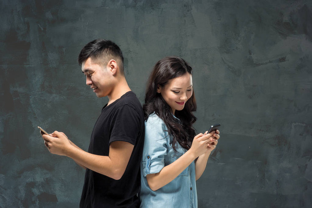 Asian young couple using cellphone, closeup portrait. - Фото, зображення