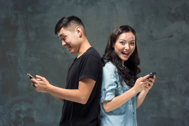 Asian young couple using cellphone, closeup portrait. - Foto, Imagen