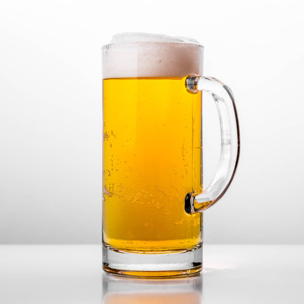Glass of fresh beer on white background - Fotó, kép