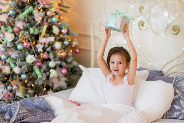 Child girl wake up in her bed in Christmas morning - Foto, Bild