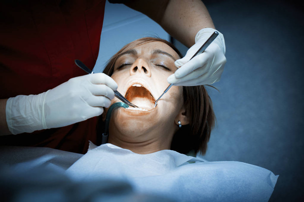Dentist examining a patients teeth before oral surgery at the de - Photo, Image