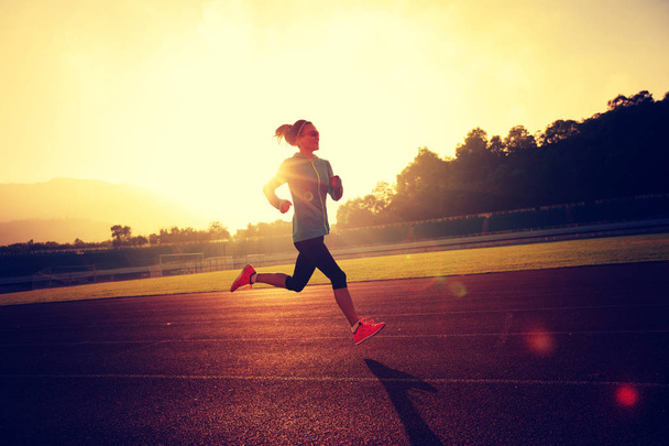 Nuori nainen juoksee stadionilla
   - Valokuva, kuva
