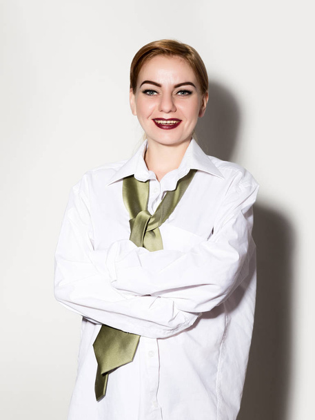 smiling naked young woman in a mans white shirt with a green tie - Foto, immagini