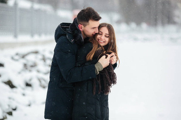 ζευγάρι, θέτοντας σε ένα χιονισμένο πάρκο - Φωτογραφία, εικόνα
