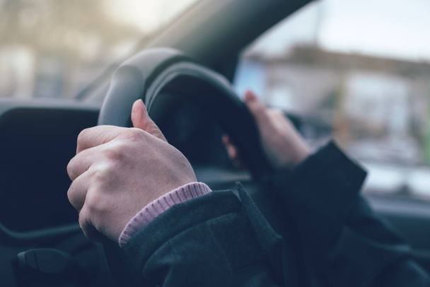 Female hands gripping the steering wheel of a car - Фото, зображення