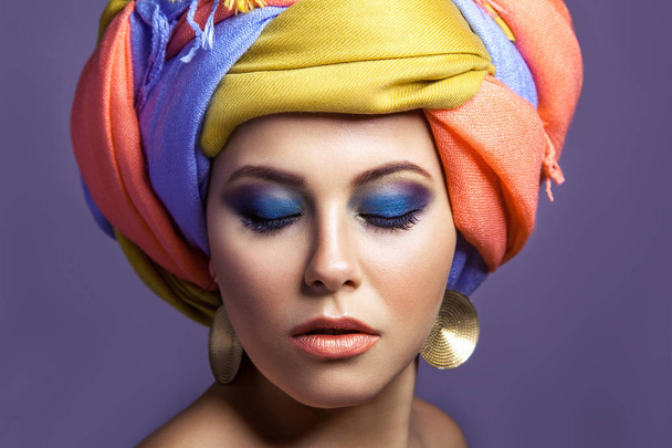 Beautiful woman with colored headwear and blue makeup. - Fotoğraf, Görsel