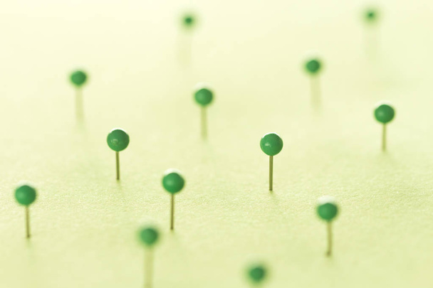 Green pins on green background - Foto, afbeelding