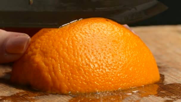 Close-up. Womens hands cut juicy orange wedges - Felvétel, videó