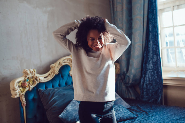 Beautiful African girl dressed in blank sweatshirt standing in the old style room. Mock-up. - Valokuva, kuva
