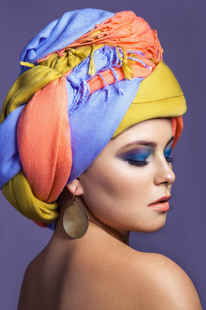 Beautiful woman with colored headwear and blue makeup. - Valokuva, kuva