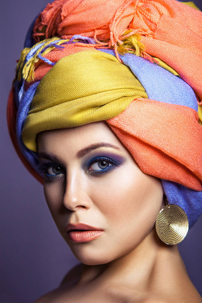 Beautiful woman with colored headwear and blue makeup. - Zdjęcie, obraz