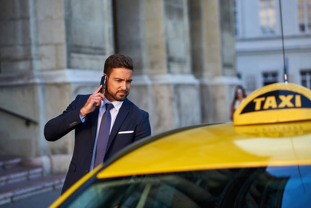 Young businessman with a taxi - Fotoğraf, Görsel