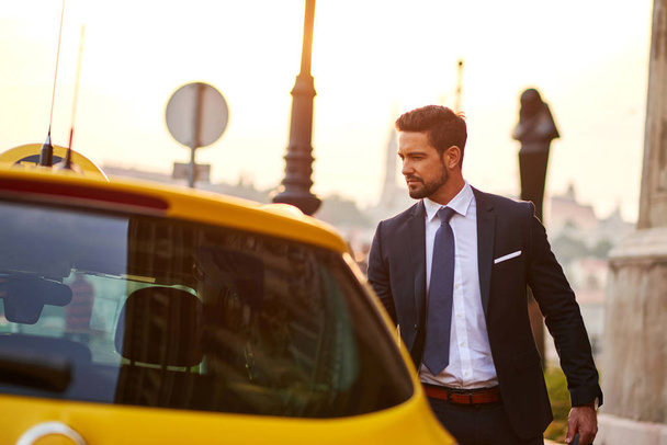 Young businessman with a taxi - Фото, зображення