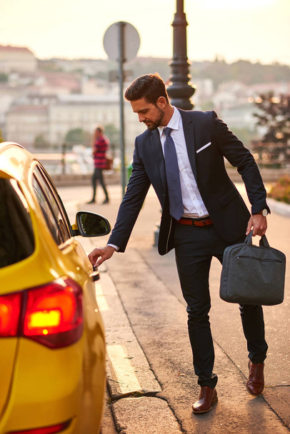 Young businessman with a taxi - Fotoğraf, Görsel