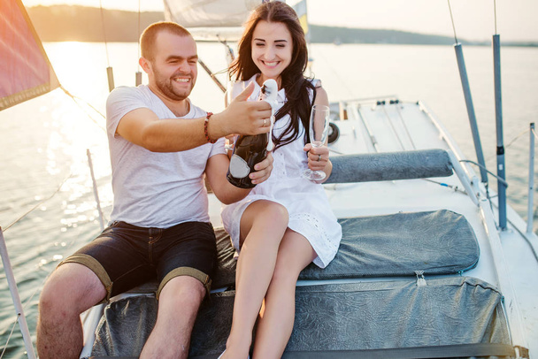 Young beautiful married couple in love at the yacht on vacation. - Фото, зображення
