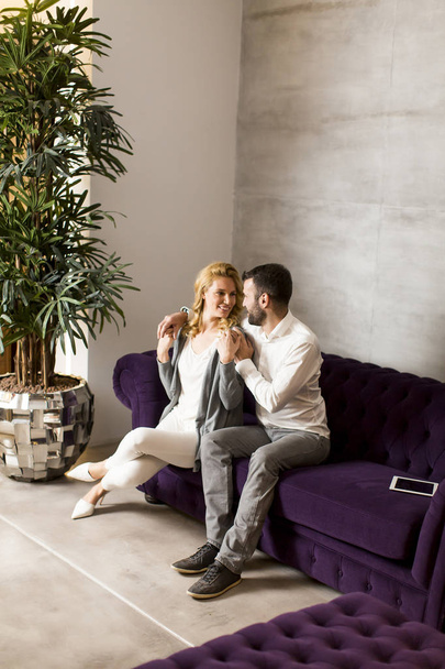 Couple sitting in sofa at home - Фото, изображение