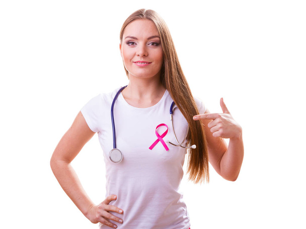 Mujer con lazo rosa ayuda símbolo y estetoscopio en el pecho
. - Foto, Imagen