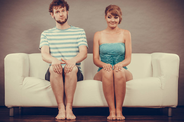 Shy woman and man sitting close to each other on couch. - Фото, зображення