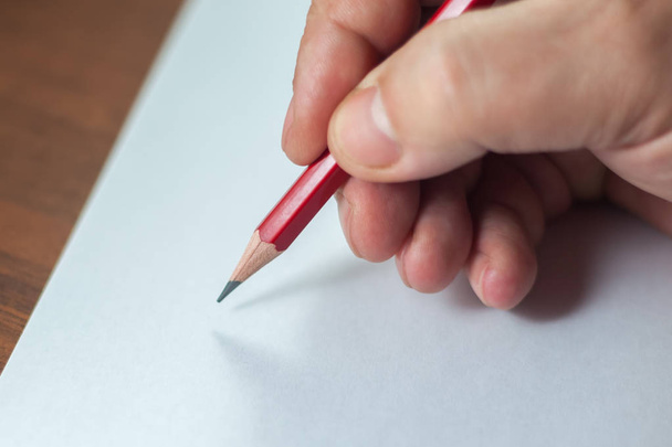 A close photo of a persons writing a letter with a pencil - Foto, Imagen