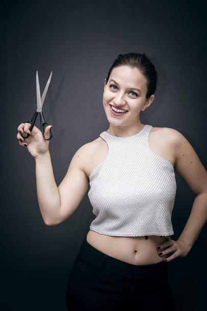 Young and beautiful girl holding a pair of scissors - Foto, immagini