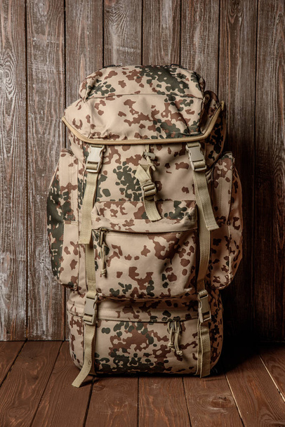 travel backpack khaki color on a wooden background - 写真・画像