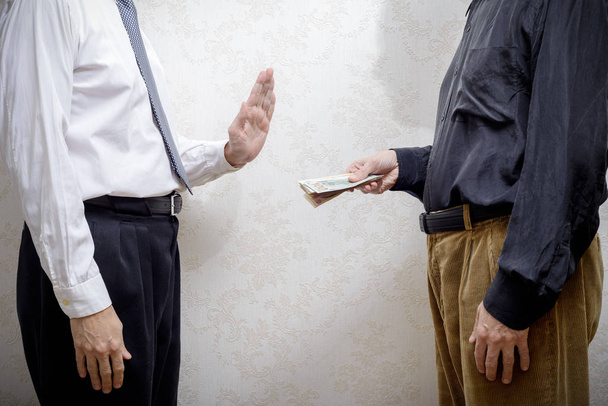 Mann bietet einem Mann, der sich weigert, ein Dollar Bestechungsgeld an - Foto, Bild