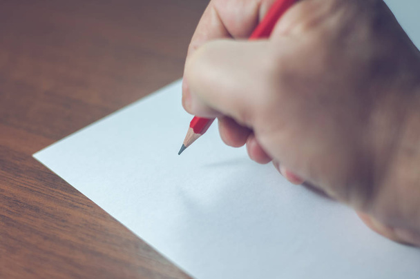A close photo of a persons writing a letter with a pencil - Foto, Bild