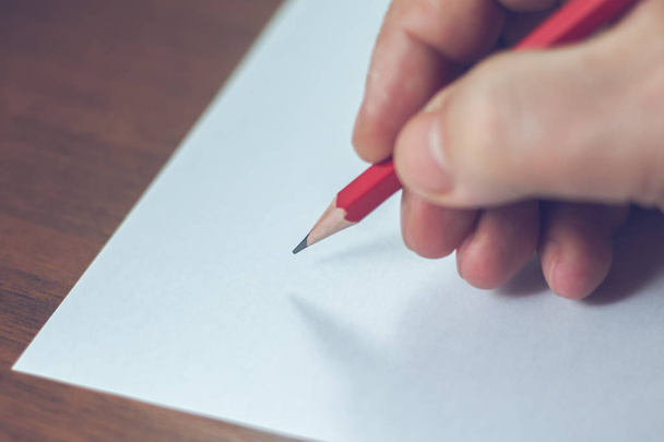 Μια κοντινή φωτογραφία του πρόσωπα γράφοντας ένα γράμμα με ένα μολύβι - Φωτογραφία, εικόνα