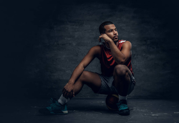 Basketball player sitting on the basket ball - Photo, Image