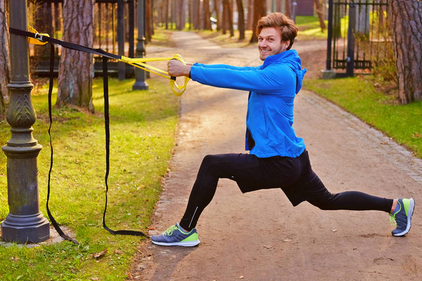 Hombre haciendo ejercicio con tiras de fitness trx
 - Foto, imagen