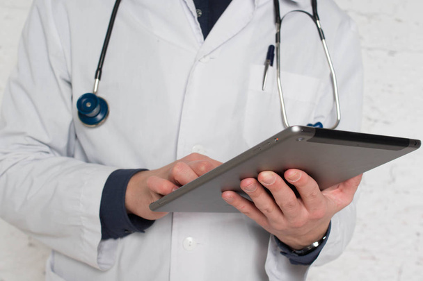 Doctor filling medical online form in the laptop tablet. The  works at the hospital - 写真・画像