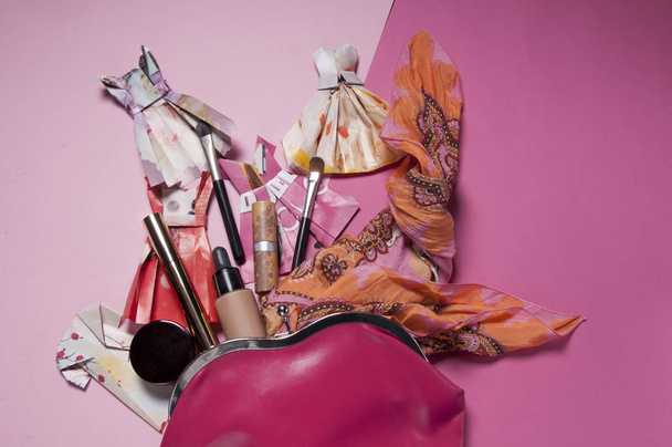 borsa rosa con sciarpa, abiti di carta e prodotti di bellezza piatto laici
 - Foto, immagini