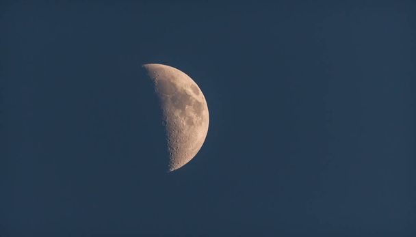 Moonshine in the dusky evening sky.  Half moon shines in evening deep blue sky. - Photo, Image